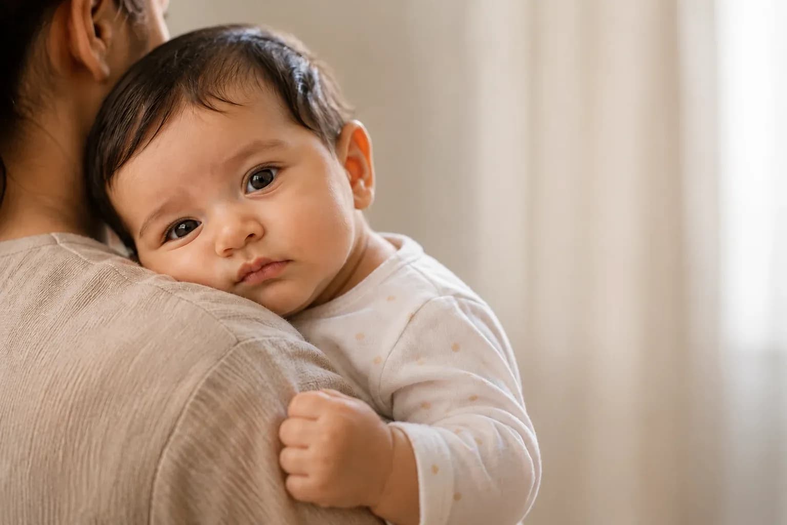 Infant with anemia resting in a caregiver's arms
