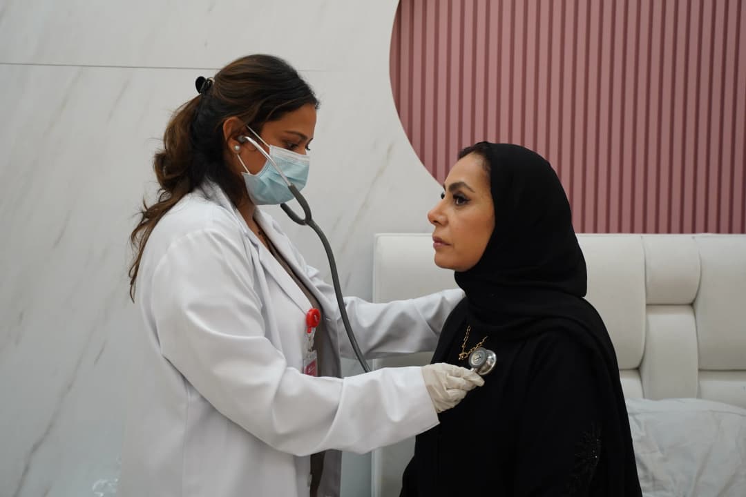 Doctor examining a patient with a stethoscope during a home visit in Qatar