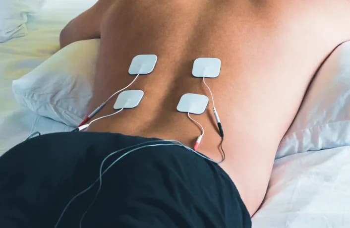 First Response Healthcare specialist administering a TENS machine treatment for targeted pain management during an at-home physiotherapy visit in Dubai.
