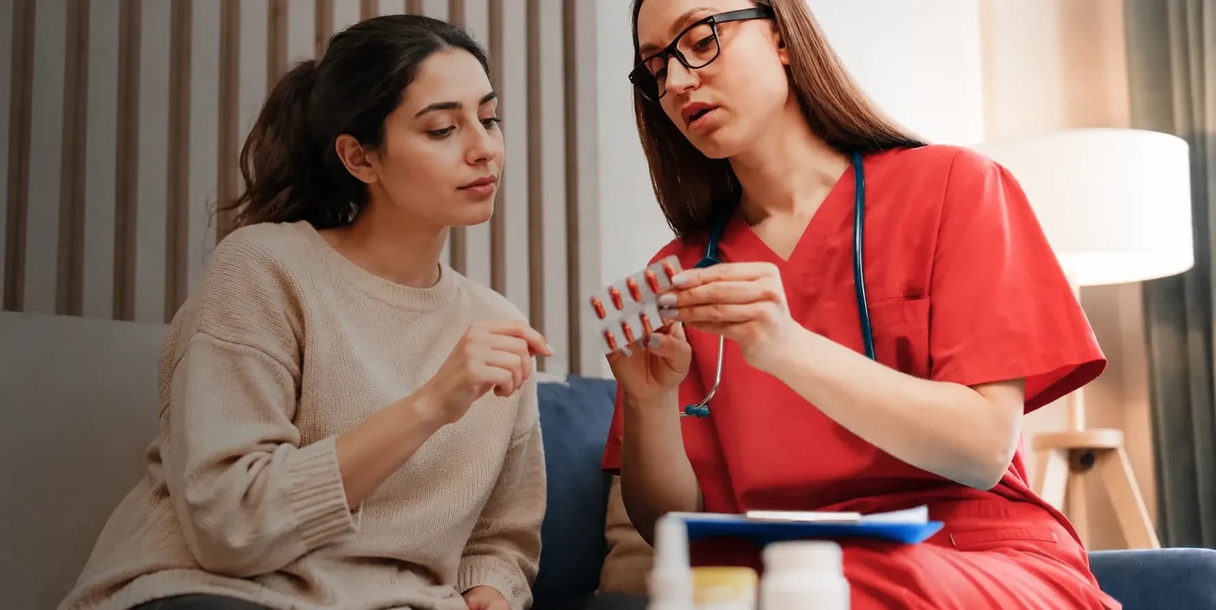 Nurse explaining health checkup results to a woman at home in Dubai
