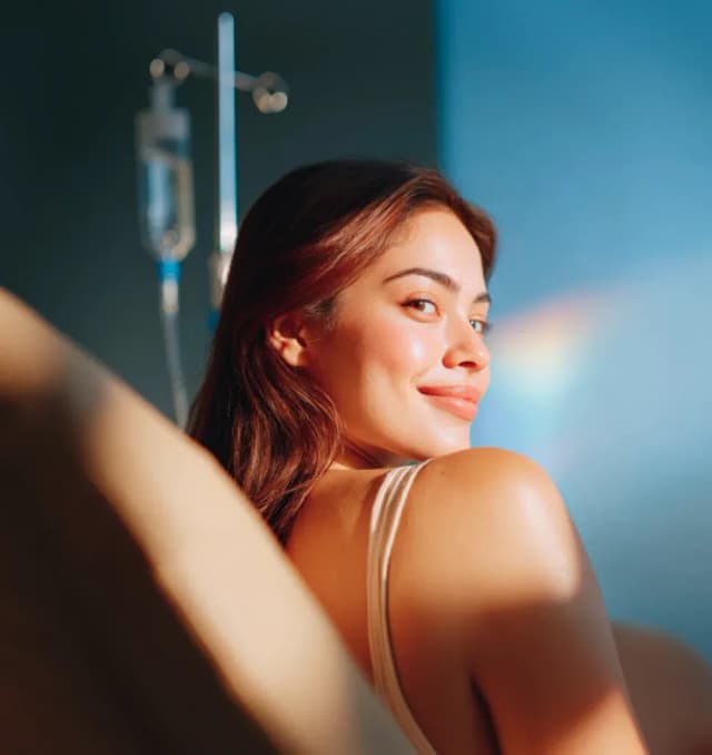 A professional home-care nurse carefully setting up a premium intravenous (IV) drip treatment for a patient to maximize health and wellness benefits.