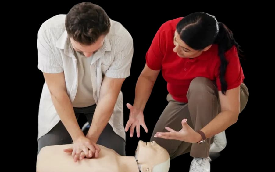 Participants practicing emergency first aid and CPR techniques on medical manikins during a hands-on, scenario-based training session.