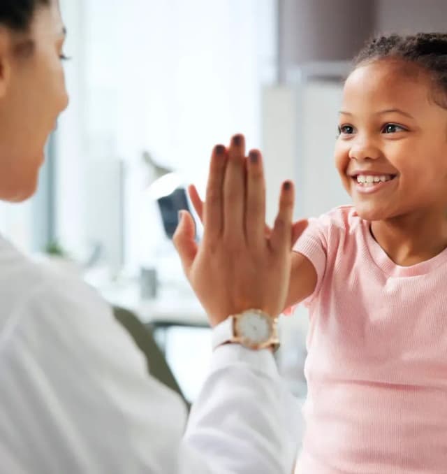 First Response Healthcare pediatrician giving a high five to a child during a home visit in Dubai