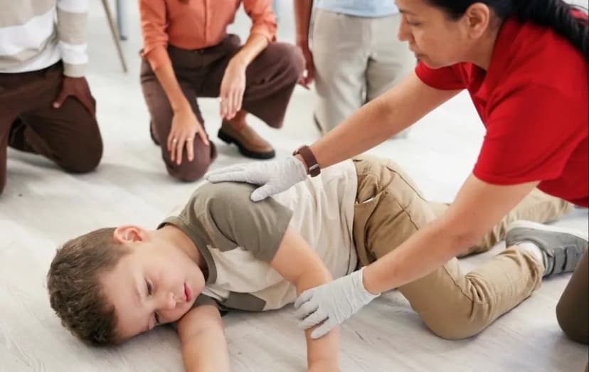 A first aid instructor demonstrating pediatric CPR and choking rescue techniques on specialized infant and child medical manikins.
