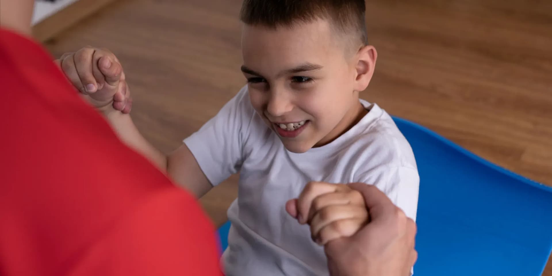 Pediatric physiotherapist explaining specialized movement and mobility skills to a child during an at-home session in Dubai.