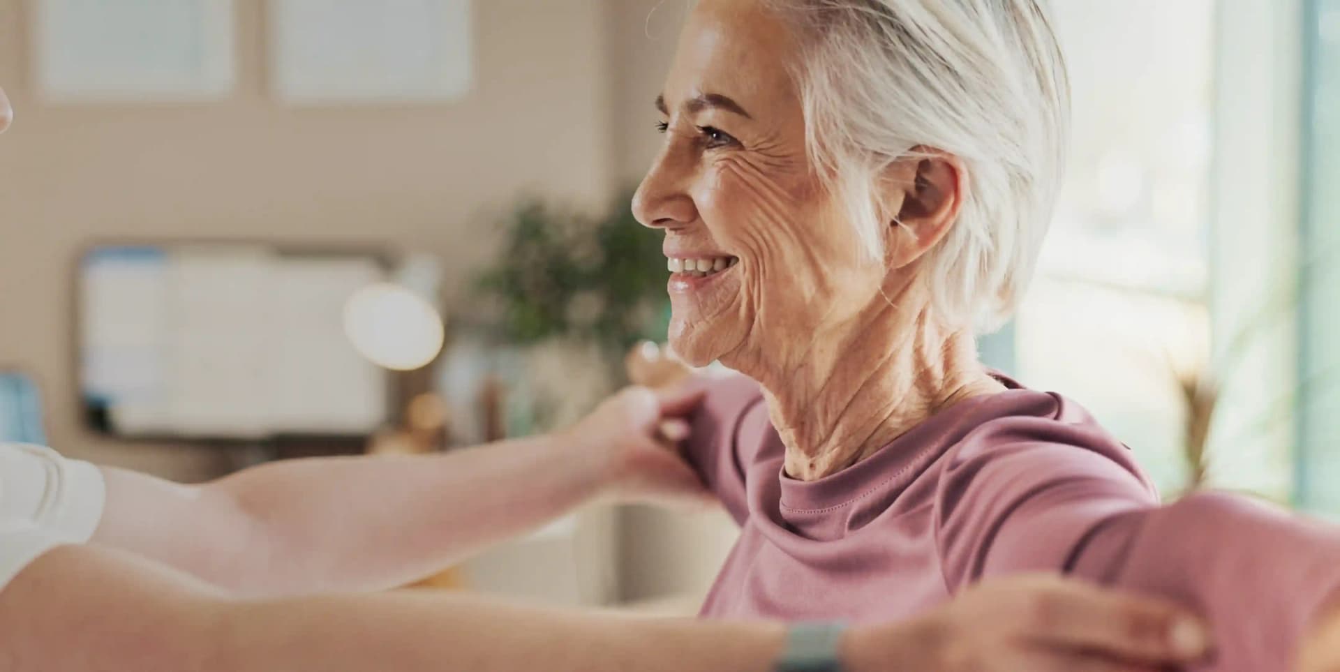A smiling elderly woman resting comfortably in bed during an at-home cardiorespiratory physiotherapy service by First Response Healthcare in Dubai.