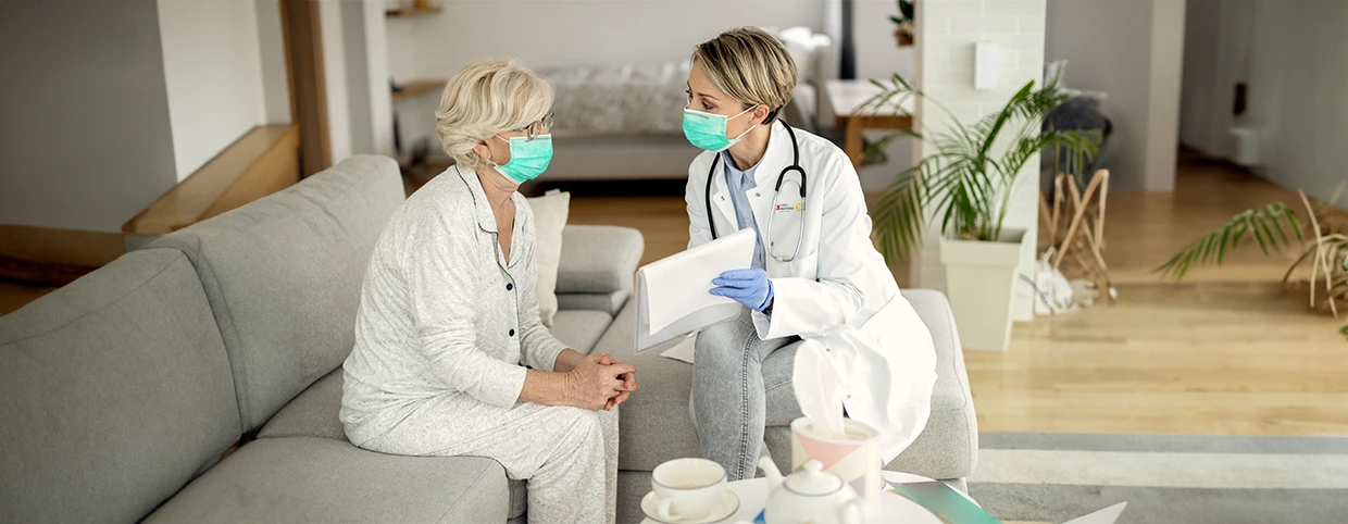 doctor giving consultation to senior patient at home