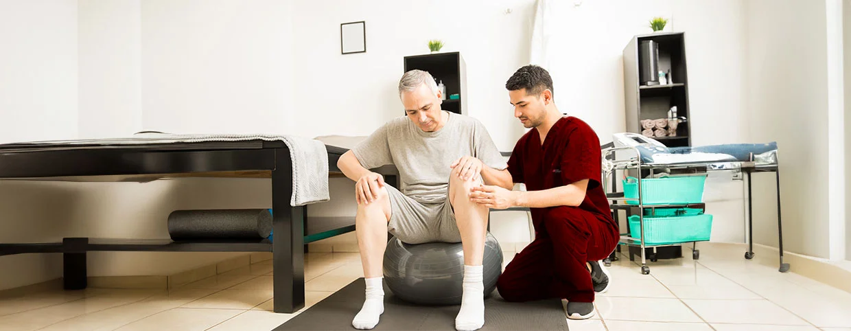 Physiotherapist understanding the chronic pain of a senior man