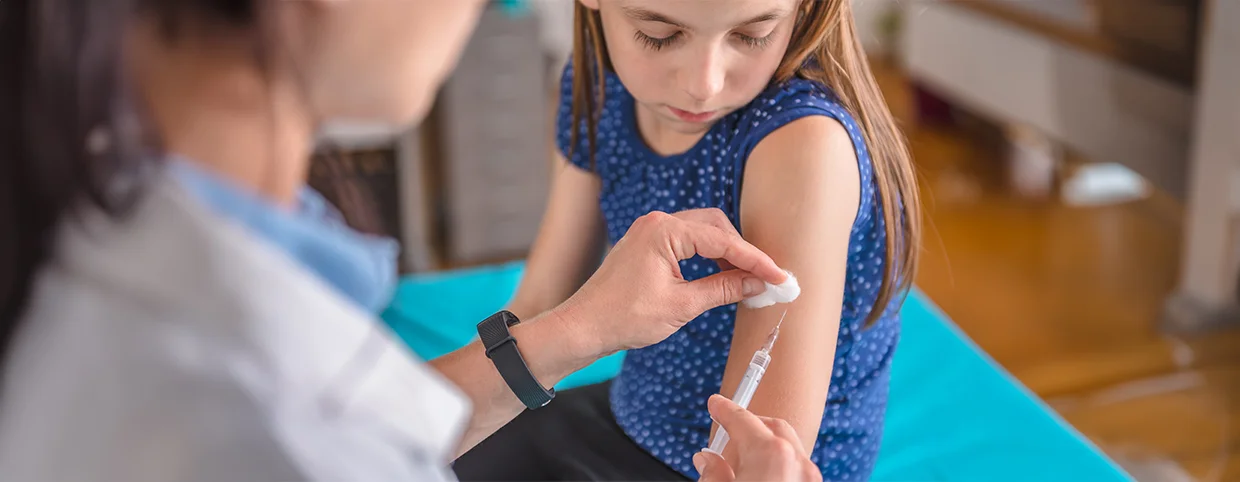 Young girl getting an injection to prevent common childhood illness