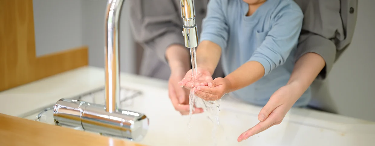 Child maintaining hand hygiene by washing his hand