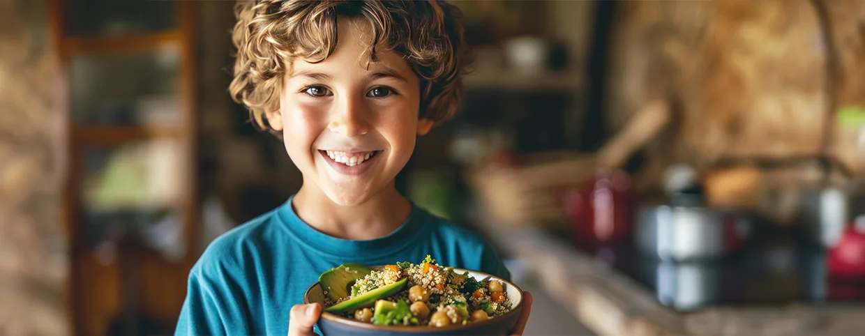 A young boy holding a bowl of salad for balanced Nutrition