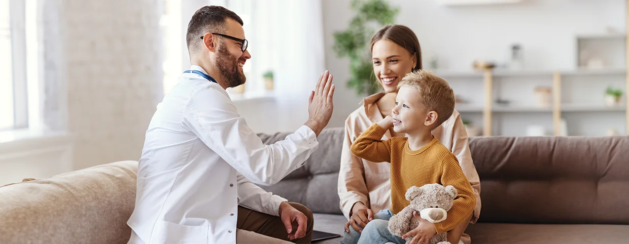 Doctor giving high fi to a small child