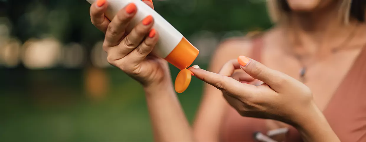 - A woman applying sunscreen to take care of her health in summer