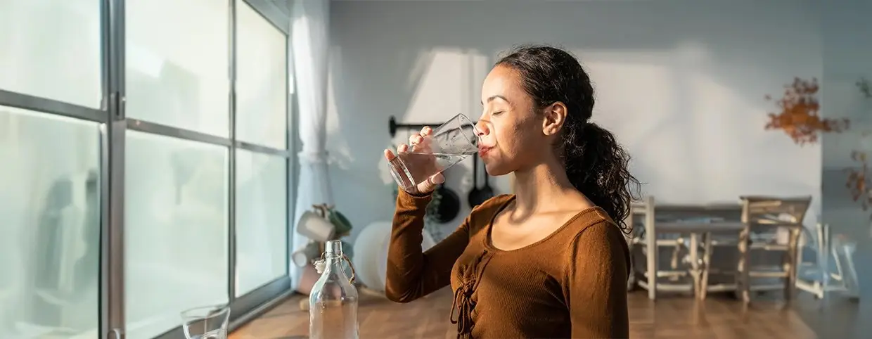 A young girl drinking water to get rid of the flu