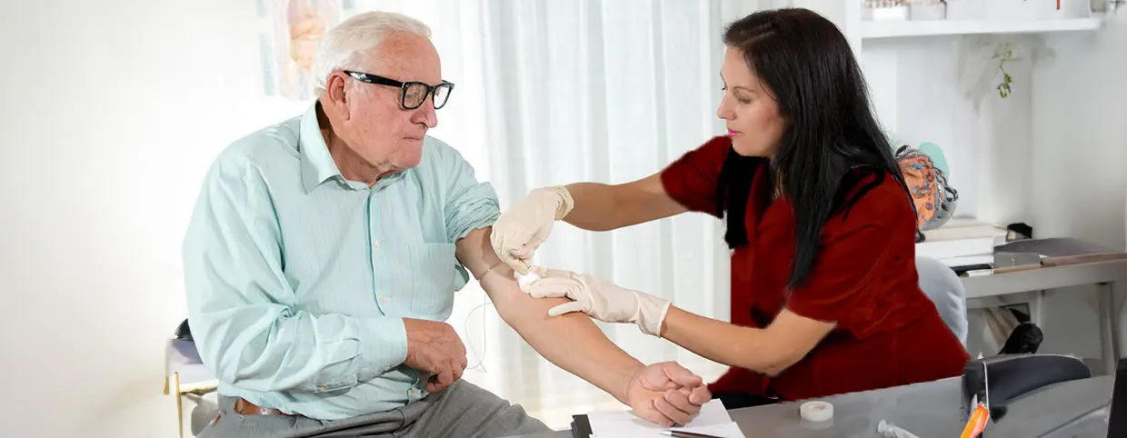 Nurse taking the blood of an old man for a blood test