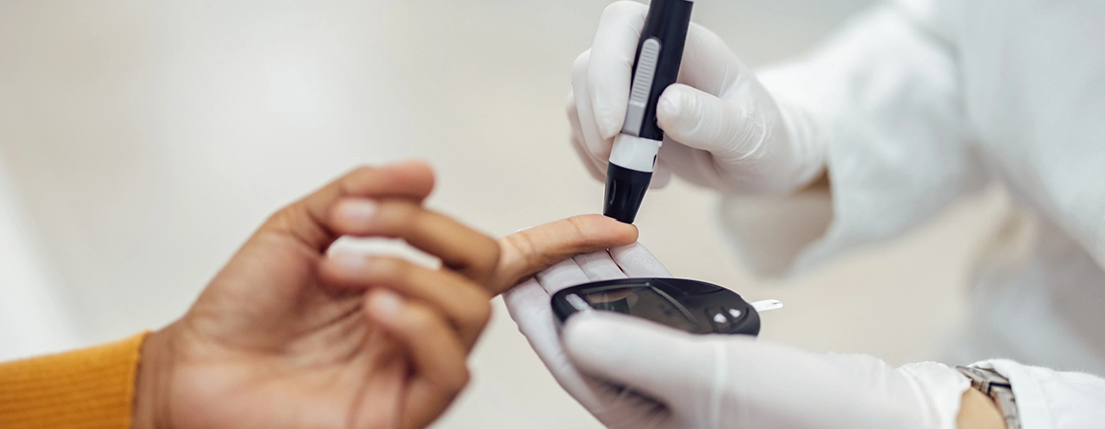 Healthcare professional assisting a patient with a blood sugar test