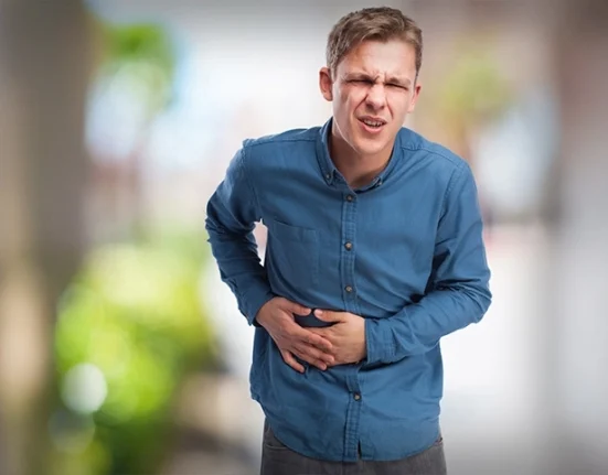 Boy holding his abdomen in discomfort or pain