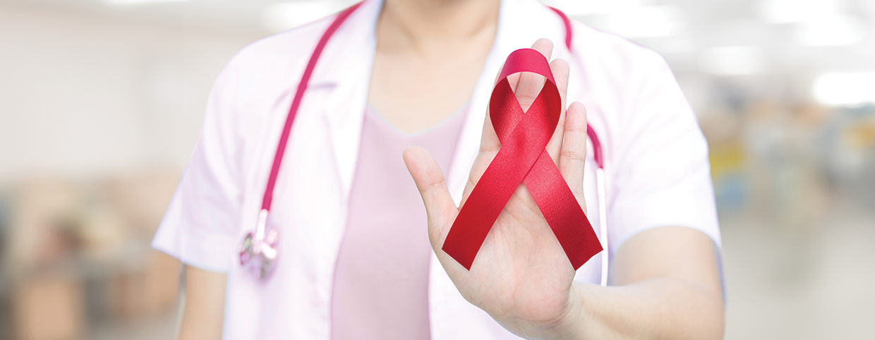 طبيبة تحمل شريطًا أحمر يرمز إلى التوعية بفيروس نقص المناعة البشرية/الإيدز