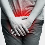 رجل يمسك أسفل بطنه بسبب ألم التهاب المسالك البولية