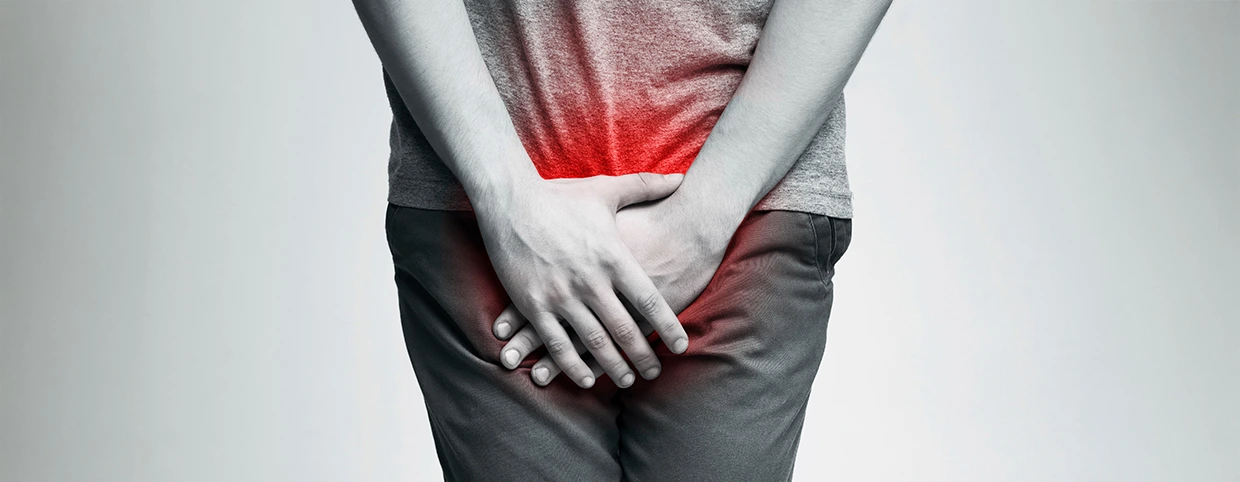 رجل يمسك أسفل بطنه بسبب ألم التهاب المسالك البولية