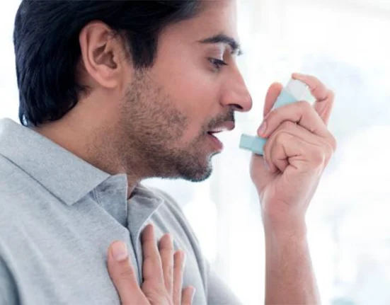 A man using an inhaler for asthma relief