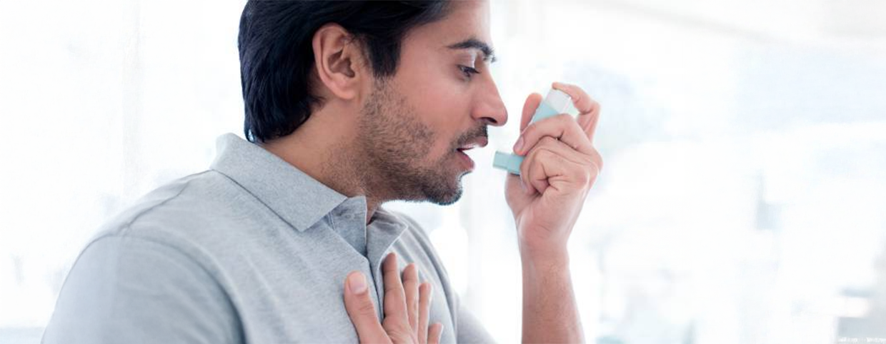 A man using an inhaler for asthma relief