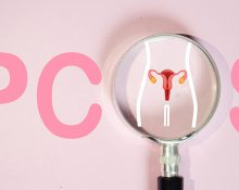 A magnifying glass highlighting a uterus illustration with the word PCOS in the background