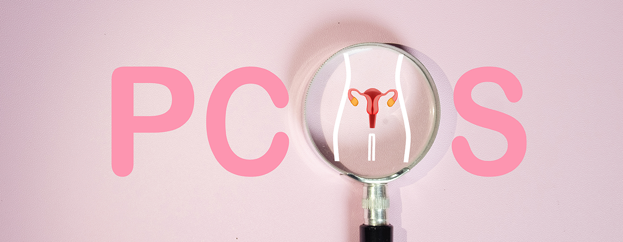 A magnifying glass highlighting a uterus illustration with the word PCOS in the background