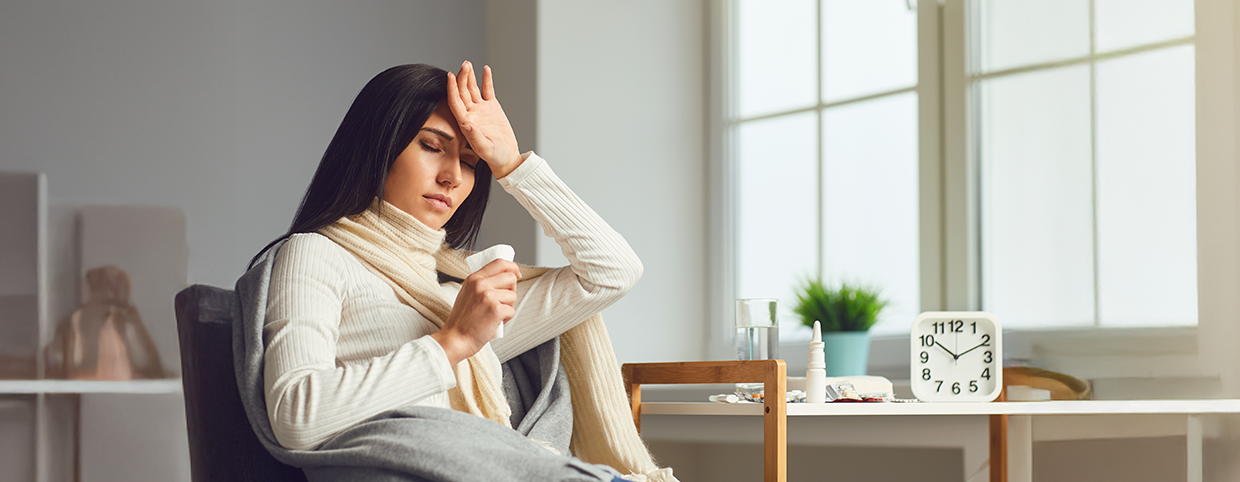A woman checking her forehead for fever